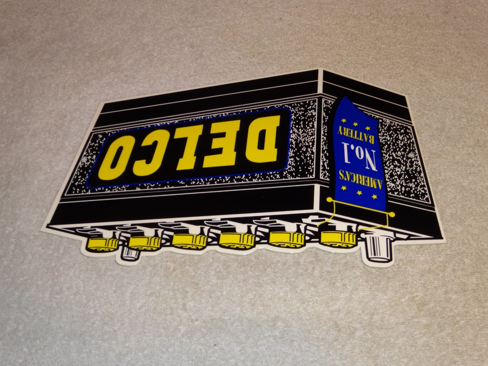 VINTAGE DELCO DIE-CUT BATTERY+ GENERAL MOTORS 12″ ENAMEL METAL GASOLINE OIL SIGN
