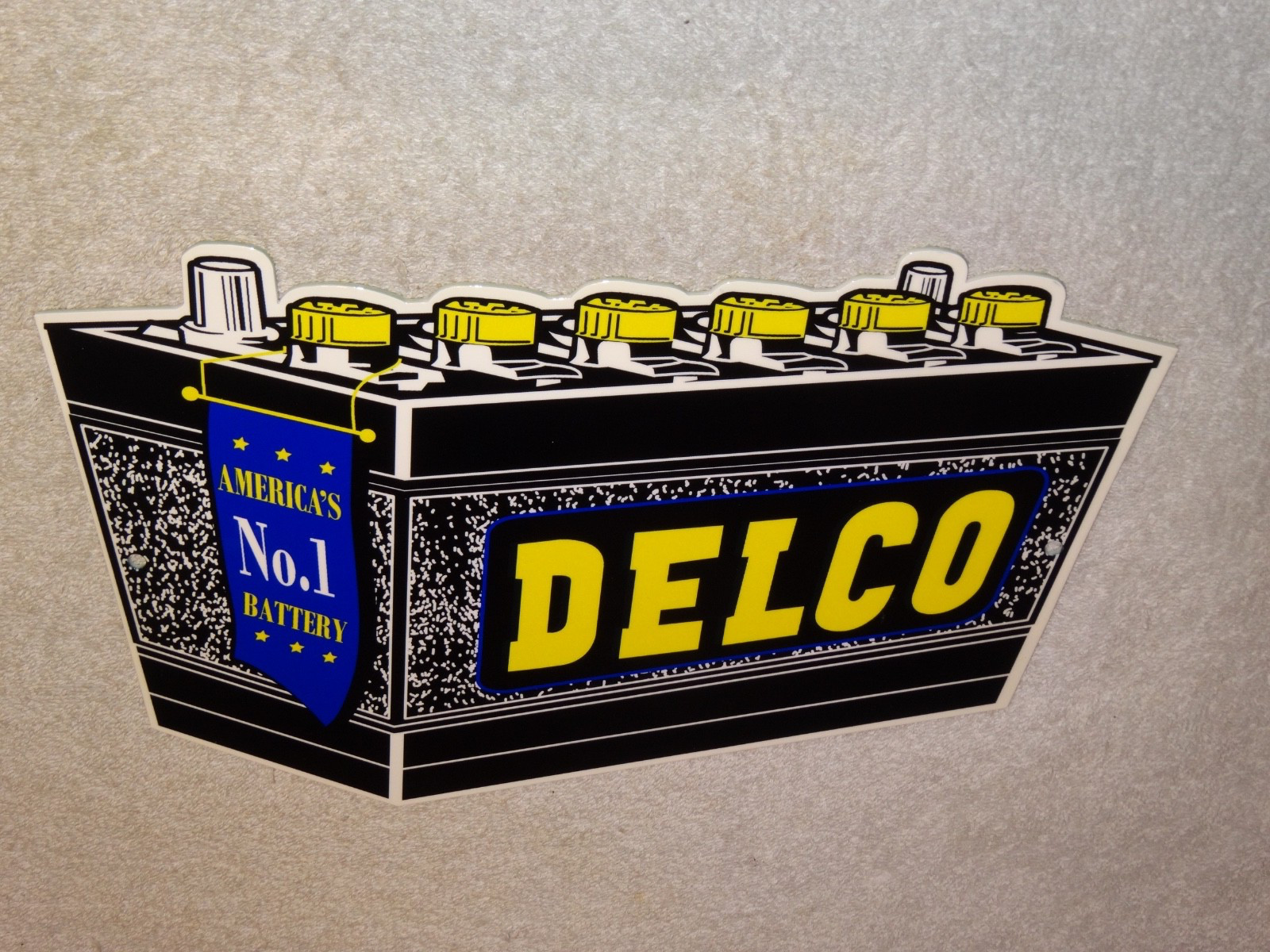 VINTAGE DELCO DIE-CUT BATTERY+ GENERAL MOTORS 12″ ENAMEL METAL GASOLINE OIL SIGN