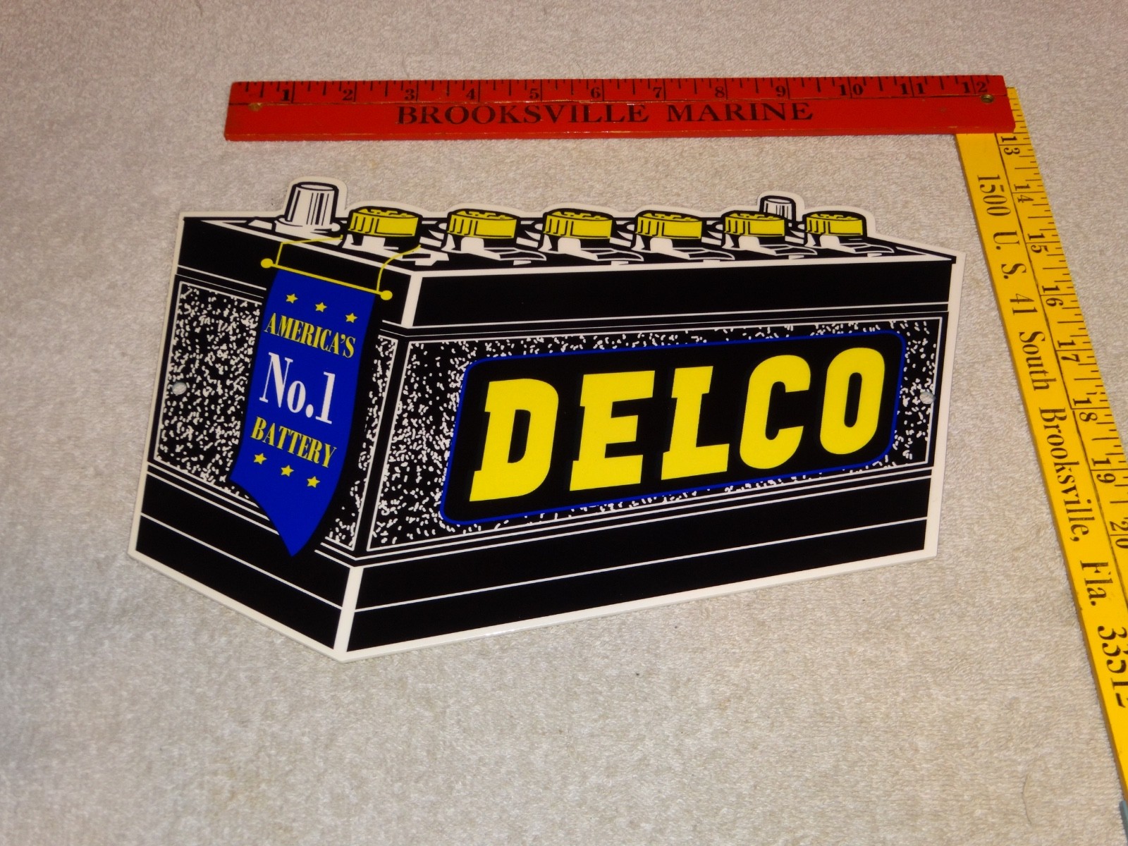 VINTAGE DELCO DIE-CUT BATTERY+ GENERAL MOTORS 12″ ENAMEL METAL GASOLINE OIL SIGN