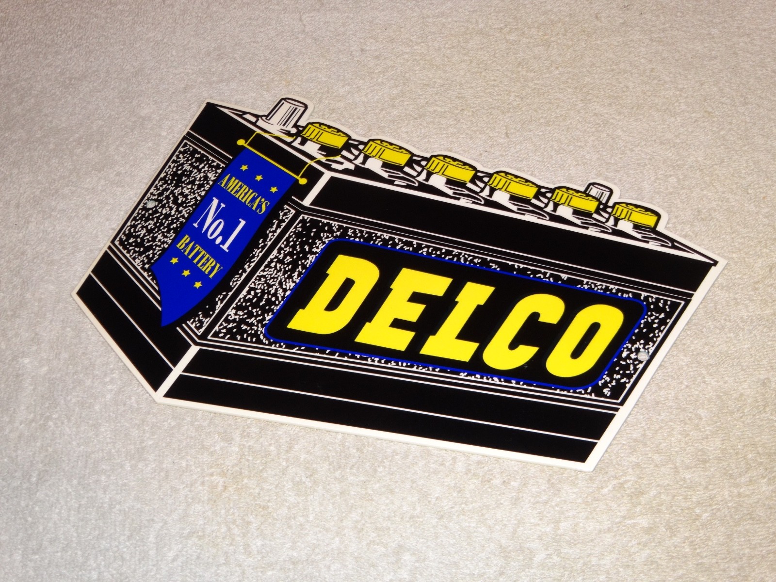 VINTAGE DELCO DIE-CUT BATTERY+ GENERAL MOTORS 12″ ENAMEL METAL GASOLINE OIL SIGN